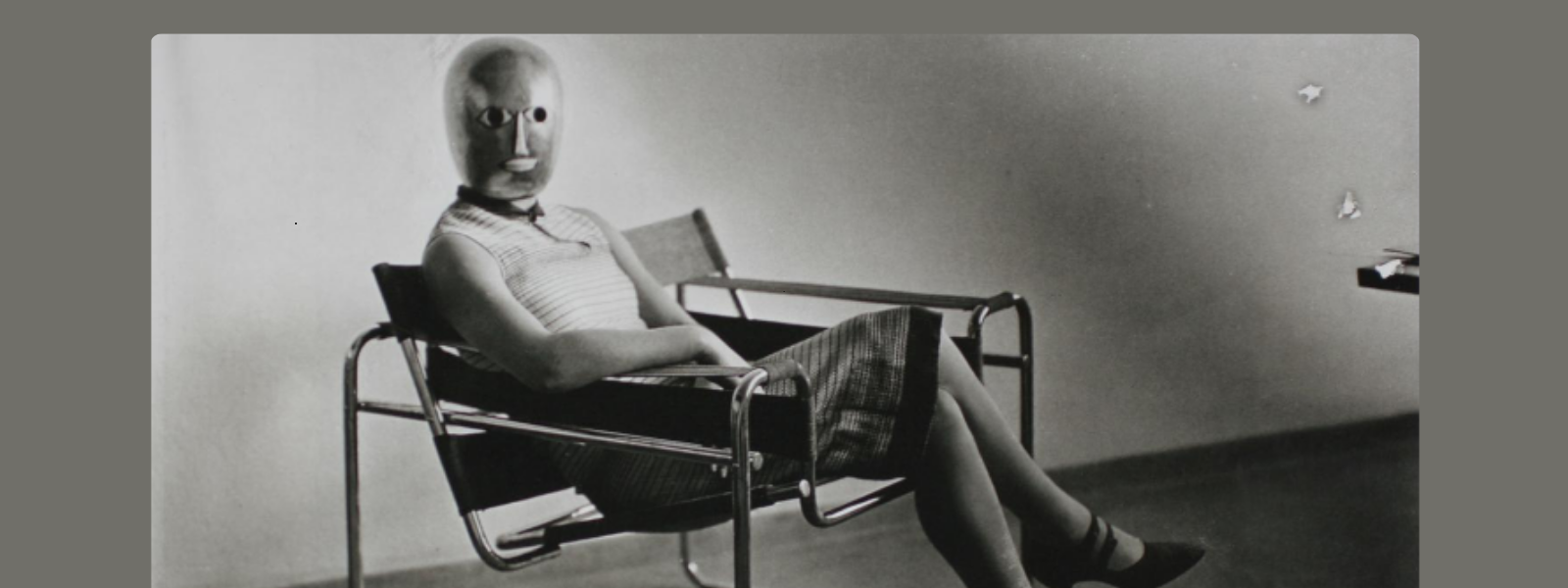 A person wearing a plain mask and casual attire sits in a modern chair against a minimalist backdrop. The scene conveys a surreal, mysterious tone.