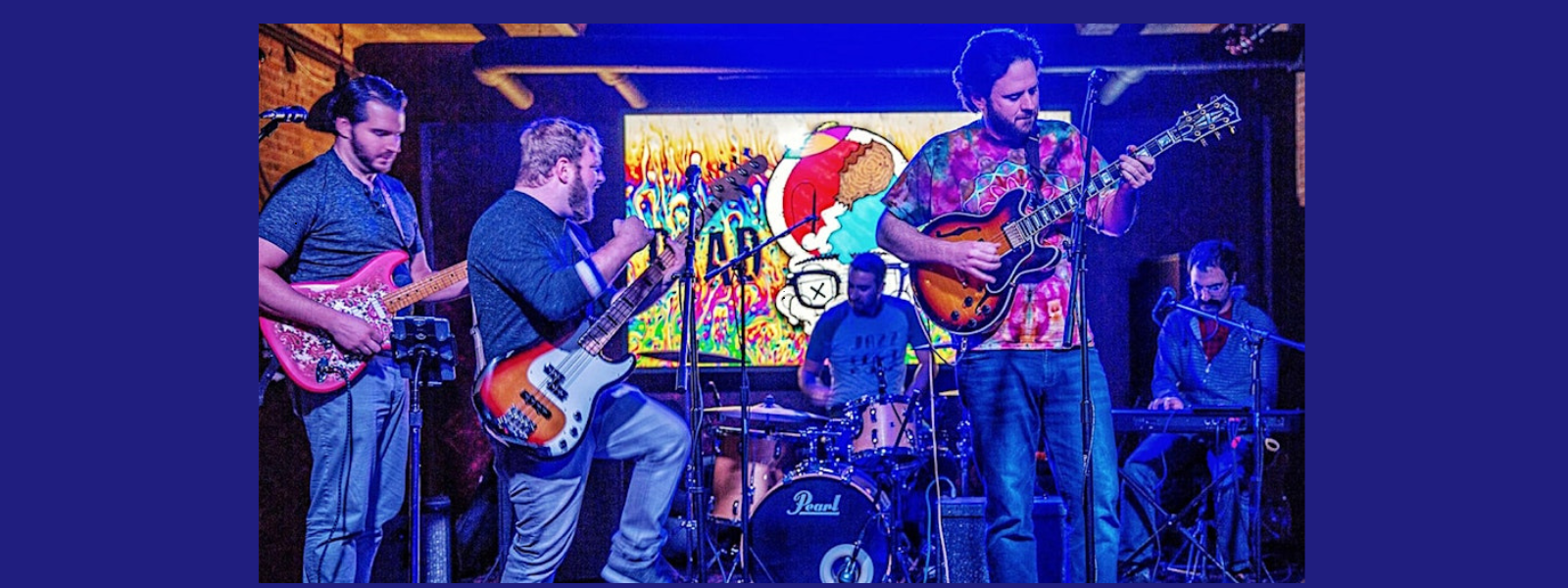 A five-member band performs on stage with vibrant, colorful lights in the background. The musicians play guitars, bass, drums, and keyboard, creating an energetic atmosphere.